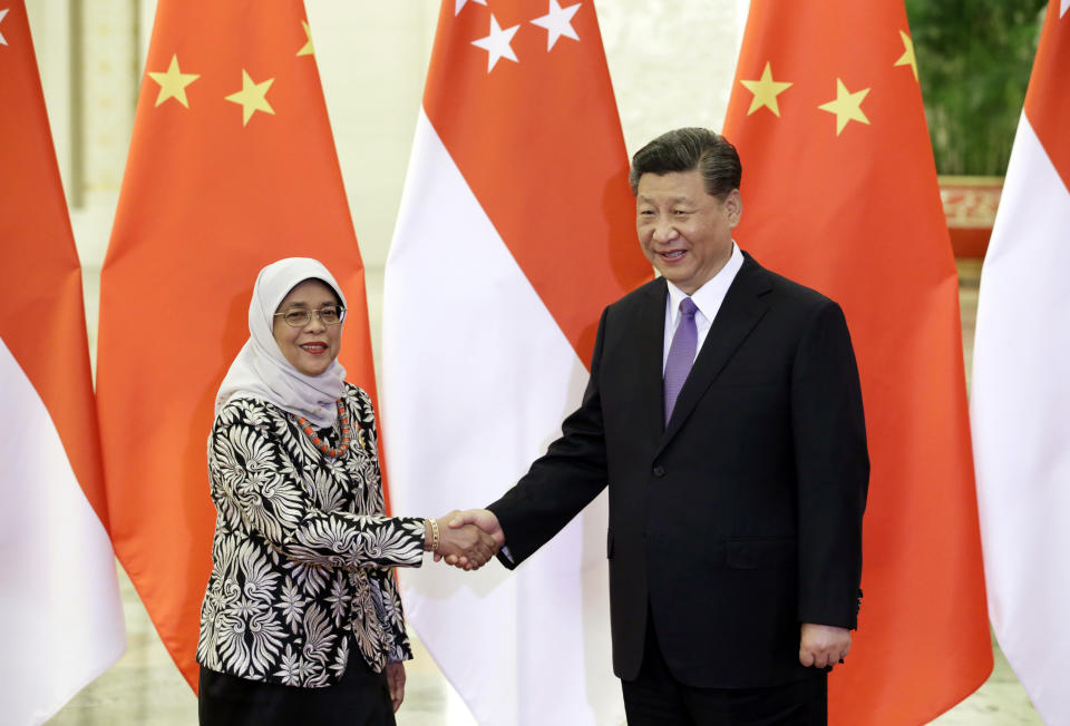 Singapore President Halimah Yacob, left, and Chinese President Xi Jinping shake hands at the Great Hall of the People in Beijing, Tuesday, May 14, 2019. (Jason Lee/Pool Photo via AP)