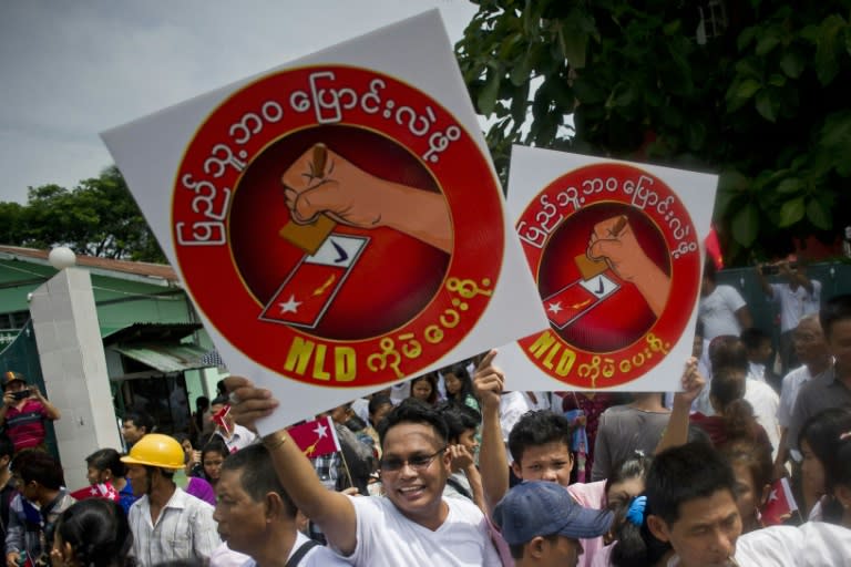 National League for Democracy supporters hold up posters in support of Aung San Suu Kyi (not pictured) after she submitted her electoral application at a district court in Yangon, on July 29, 2015