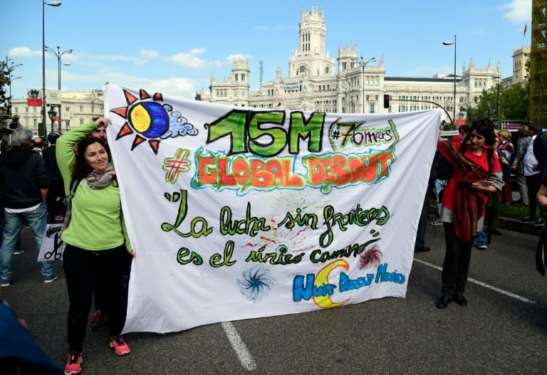 Women carry a banner reading: "The fight without frontiers is the only way" as they march during a demonstration marking the fifth anniversary of the "Indignados" movement in Madrid, on May 15, 2016