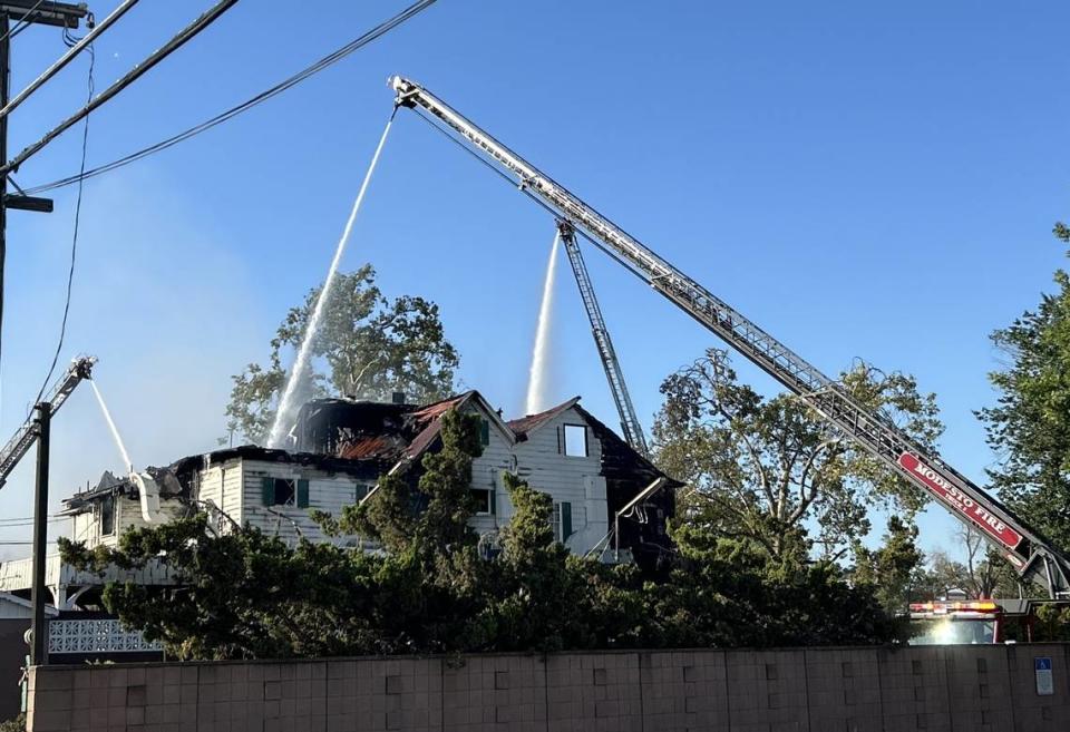 Los bomberos trabajan para extinguir las llamas en el antiguo edificio de Franklin and Downs Funeral Homes, en la esquina de la 12th y la G, en el centro de Modesto, el martes 16 de julio de 2024 por la mañana.