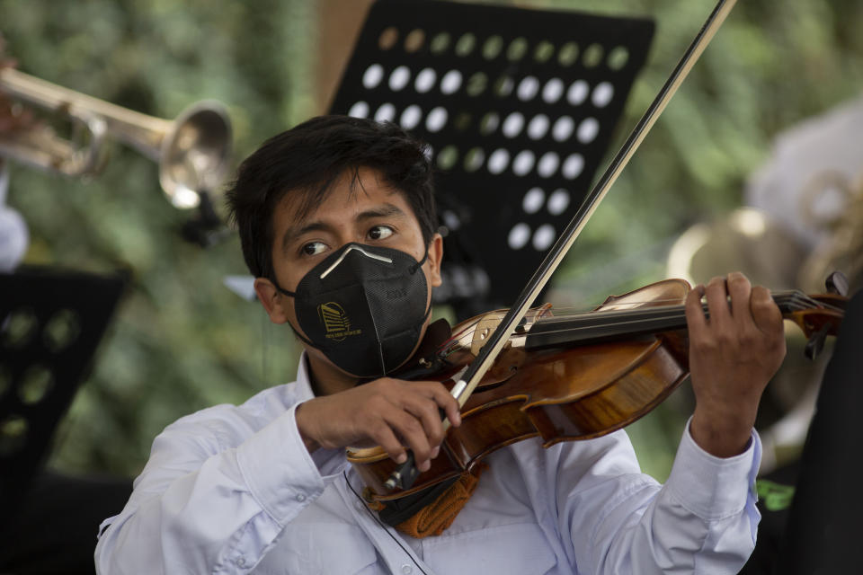 A musician plays during a tribute by health workers at the San Juan de Dios hospital in memory of their colleagues who died from COVID-19, at the hospital in Guatemala City, Friday, Oct. 9, 2020. (AP Photo/Moises Castillo)