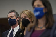 Gov. Gavin Newsom, from left, Assemblywoman Buffy Wicks, D-Oakland, and Oakland Mayor Libby Schaaf listen to spekers at a news conference in Oakland, Calif., Monday, July 26, 2021. California will require state employees and all health care workers to show proof of COVID-19 vaccination or get tested weekly. Officials are tightening restrictions in an effort to slow rising coronavirus infections in the nation's most populous state, mostly among the unvaccinated. (AP Photo/Jeff Chiu)