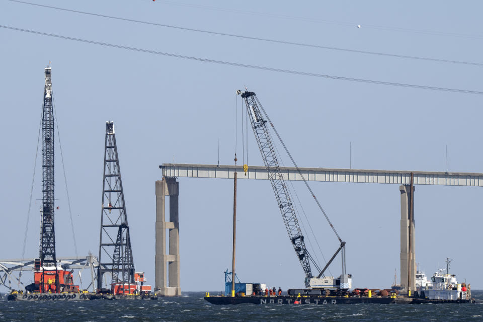 Barges with cranes float near a damaged section of the Francis Scott Key Bridge, Friday, March 29, 2024, in Baltimore, Md. (AP Photo/Mark Schiefelbein)