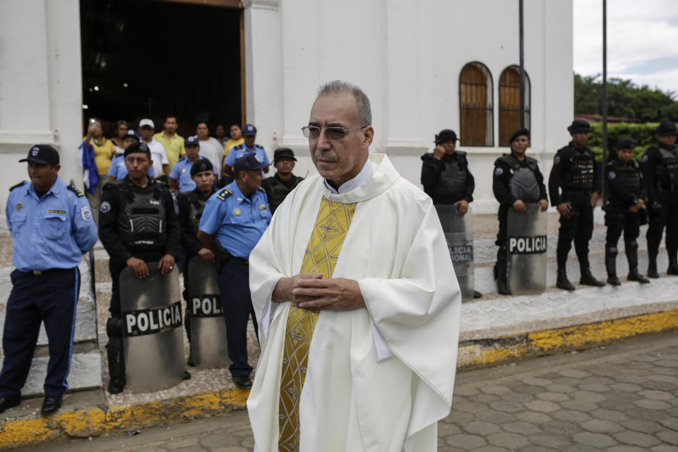 Father Edwin Roman attempts to convince the police to allow relatives of imprisoned and dead anti-government demonstrators to enter the San Miguel Arcangel Church in Masaya, Nicaragua, Thursday, Nov. 14, 2019. The relatives have started a hunger strike to demand the freedom of their relatives, jailed for protesting against the government of President Daniel Ortega. (AP Photo/Alfredo Zuniga)