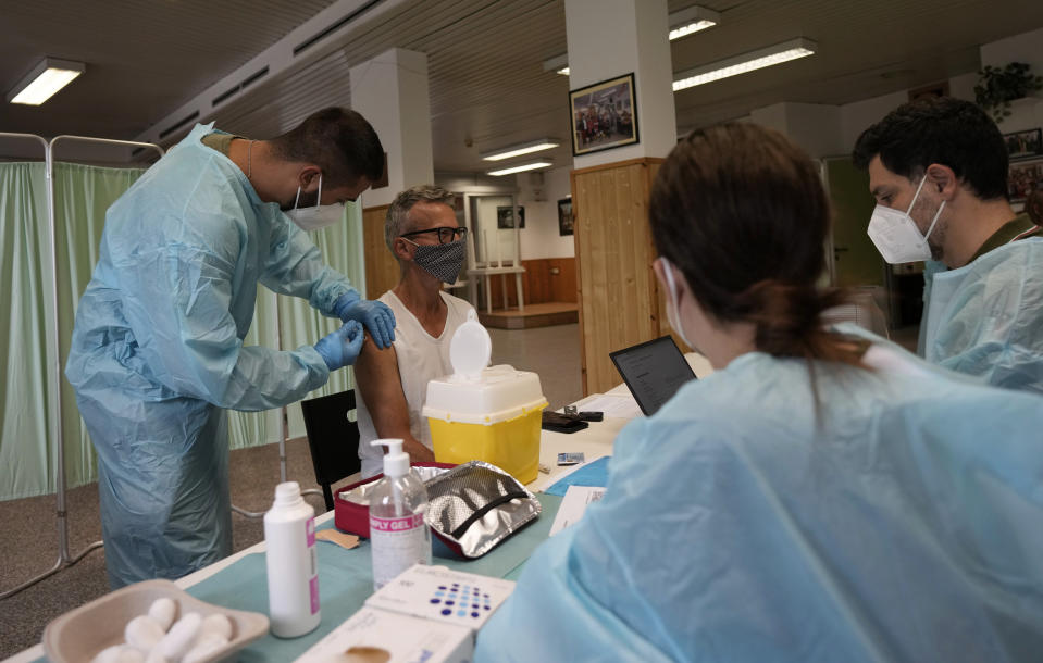 Medical workers administer the Johnson & Johnson vaccine for COVID-19 to Carlo Picella at a cultural center on the outskirts of Milan, Italy, Wednesday, July 28, 2021. A camper van will tour Milan and the Lombardy region to provide easy vaccinations without bookings in an attempt to boost the vaccination campaign. Europe’s famed summer holiday season is in full swing, but efforts to inoculate people against coronavirus are not taking a break. From France’s Mediterranean coast to Italy’s Adriatic beaches, health authorities are trying to make a COVID-19 shot as much a part of this summer as sunscreen and shades. (AP Photo/Antonio Calanni)