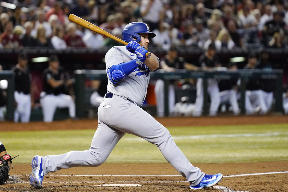 Los Angeles Dodgers' Max Muncy watches his infield ground ball during the third inning of a baseball game against the Arizona Diamondbacks, Thursday, April 6, 2023, in Phoenix. Muncey reached first base safely on a throwing error by Diamondbacks' Geraldo Perdomo. (AP Photo/Ross D. Franklin)