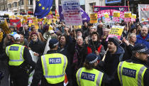 People take part in an anti-fascist counter-demonstration against the "Brexit Betrayal Rally" led by English far-right activist Tommy Robinson who serves as a political adviser to the Leader of the UK Independence Party, UKIP, in central London, Sunday Dec. 9, 2018. Police patrolled the route and separated the two rallies. (Victoria Jones/PA via AP)