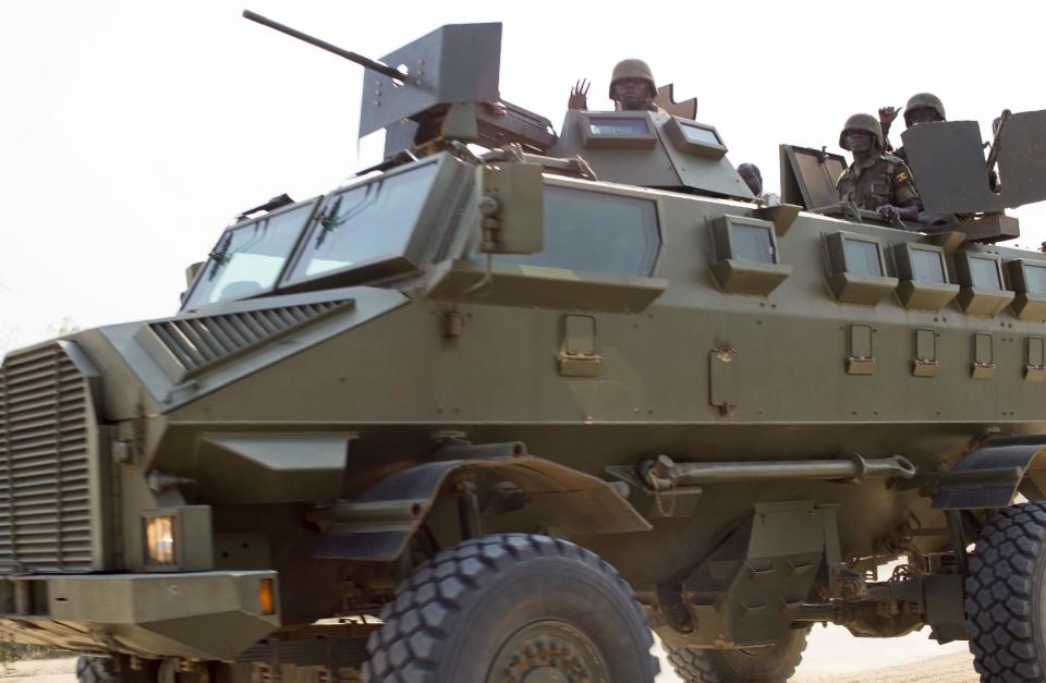 Soldiers from the Uganda People's Defence Force (UPDF) drive in an armoured vehicle through the streets of Bor, Jonglei State, South Sudan Sunday, Jan. 19, 2014. Leaders for warring sides in South Sudan's monthlong internal conflict say they are close to signing a cease-fire and the South Sudanese military spokesman said that army forces had retaken the key city of Bor Saturday, defeating 15,000 rebels. (AP Photo/Mackenzie Knowles-Coursin)