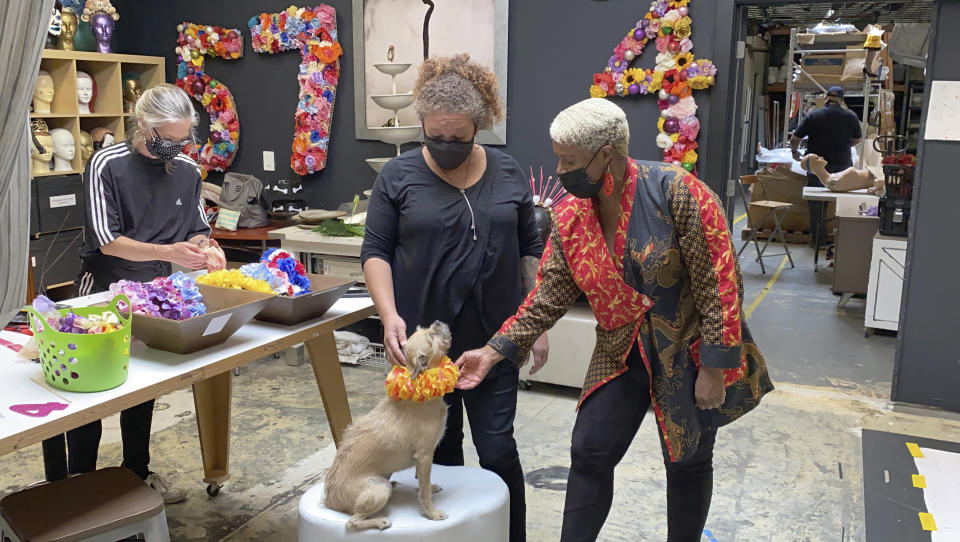 Judi Henderson, owner of Mannequin Madness, interacts on Tuesday, Sept. 15, 2020, with an employee and her dog at her store in Oakland, Calif., which sells used mannequins, hosts art classes and has a portrait studio for people and dogs. She received a grant from the Oakland African American Chamber of Commerce's "Resiliency Fund," which seeks to help Black-owned businesses stay afloat during the coronavirus pandemic. (AP Photo/Terry Chea)