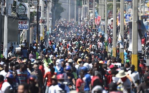 Demonstrators march on the streets on the fifth day of protests in Port-au-Prince - Credit:  HECTOR RETAMAL/AFP