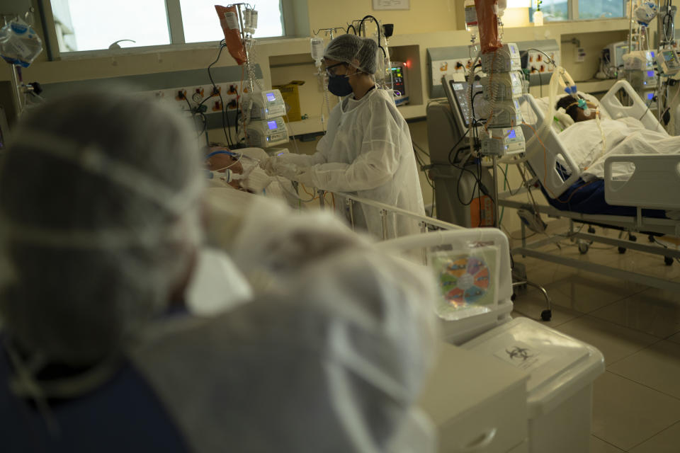 A medical worker treats a COVID-19 patient at the intensive care unit at the Oceanico hospital, in Niteroi, Brazil, Friday, Dec. 11, 2020. Cases of COVID-19 are rising again in the country with the world’s second-highest confirmed death toll and many hospitals are filling up. (AP Photo/Lucas Dumphreys)