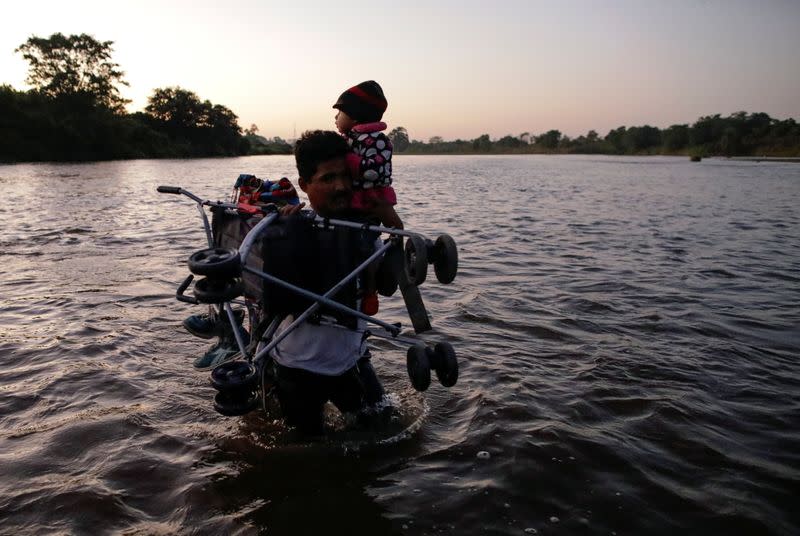 Migrants, mainly from Central America, marching in a caravan cross the Suchiate river on the outskirts of Ciudad Hidalgo