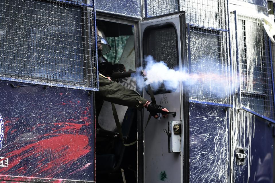 Riot police fires tear gas against protesters during clashes in Karava near the area where the government plans to build a new migrant detention center, on the northeastern Aegean island of Lesbos, Greece, Wednesday, Feb. 26, 2020. Local authorities declared a 24-hour strike on two eastern Greek islands Wednesday to protest government plans to build new migrant detention camps there. (AP Photo/Michael Varaklas)