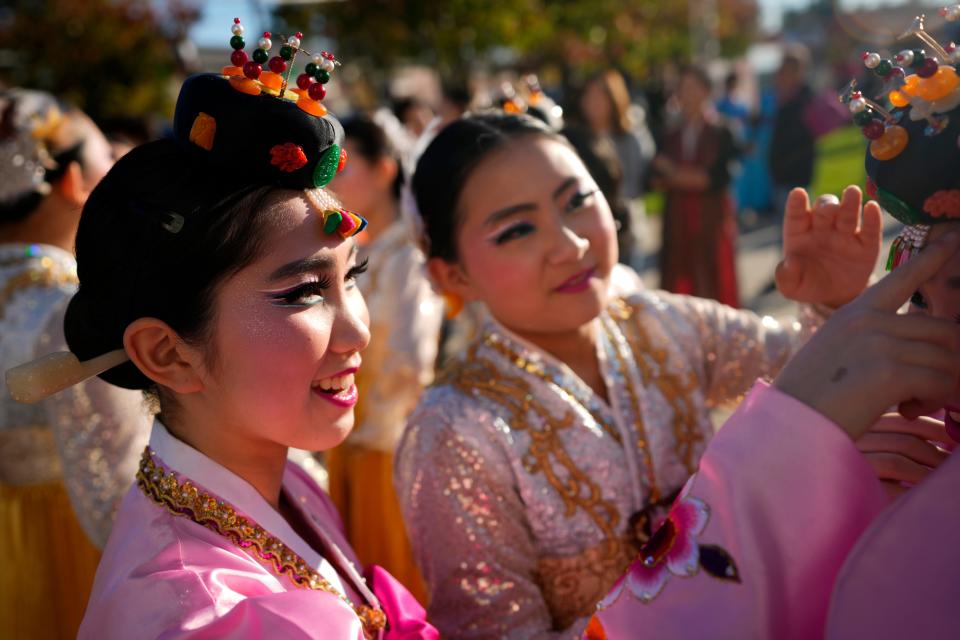 Members of the Woorigarak Korean Cultural Art Center, help each other with their traditional dress, at the Hanbok festival in Fort Lee on Sunday, October 16, 2022