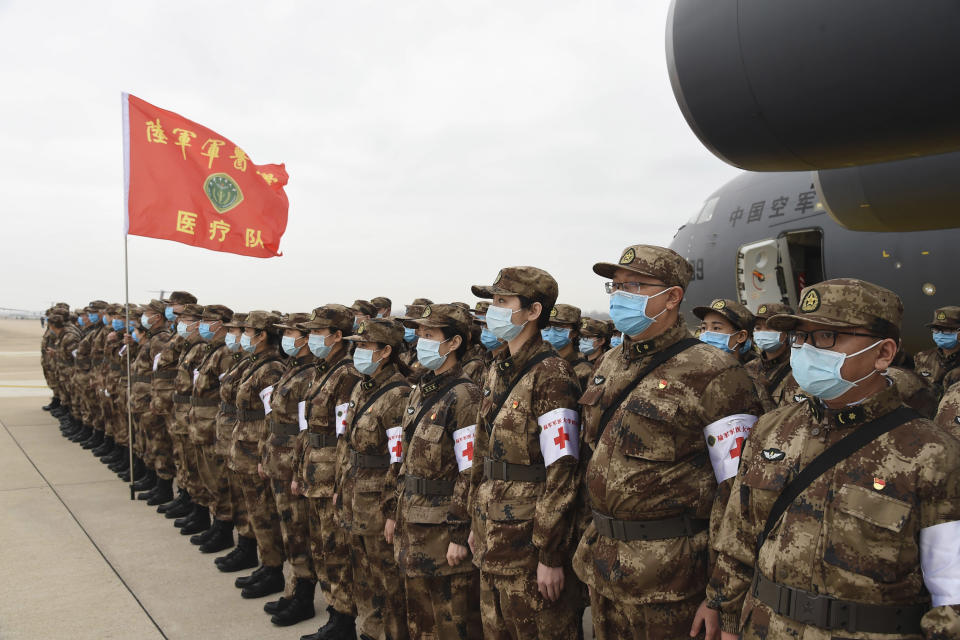 In this photo released by China's Xinhua News Agency, Chinese military medics arrive at the Tianhe International Airport in Wuhan, central China's Hubei Province, Feb. 13, 2020. China has mobilized its military resources in its fight against the COVID-19 viral outbreak. (Li Yun/Xinhua via AP)