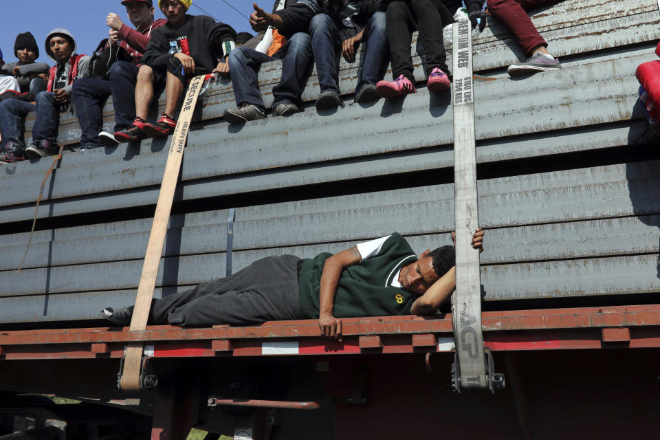 A Central American migrant, part of the caravan hoping to reach the U.S. border, sleeps while getting a ride on a truck with others, in Celaya, Mexico, Sunday, Nov. 11, 2018. Local Mexican officials were once again Sunday helping thousands of Central American migrants find rides on the next leg of their journey toward the U.S. border. (AP Photo/Rodrigo Abd)