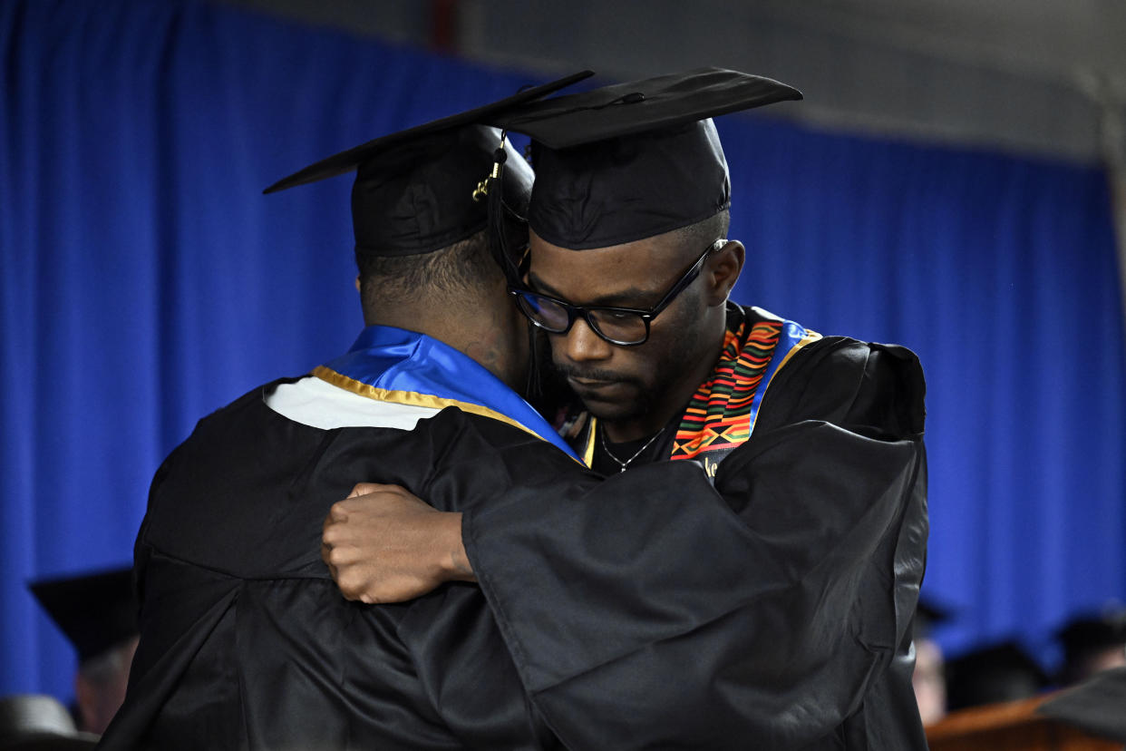 Graduates Alpha Jalloh, left, and Marcus Harvin, right, embrace at the first-ever college graduation ceremony at the MacDougall-Walker Correctional Institution on June 9 in Suffield, Conn. 