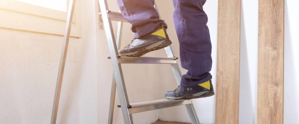 Feet of a carpenter  ready for work on a ladder