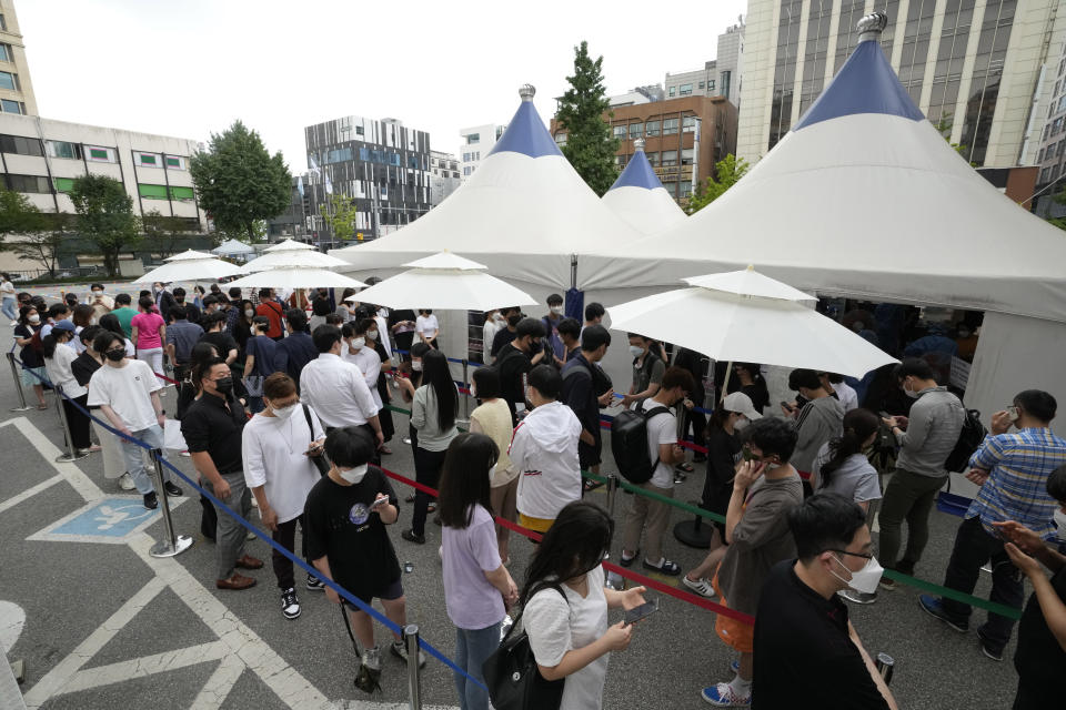 People queue in line to wait for the coronavirus testing at a Public Health Center in Seoul, South Korea, Friday, July 9, 2021. South Korea will enforce its strongest social distancing restrictions in the greater capital area starting next week as it wrestles with what appears to be the worst wave of the coronavirus since the start of the pandemic. (AP Photo/Ahn Young-joon)