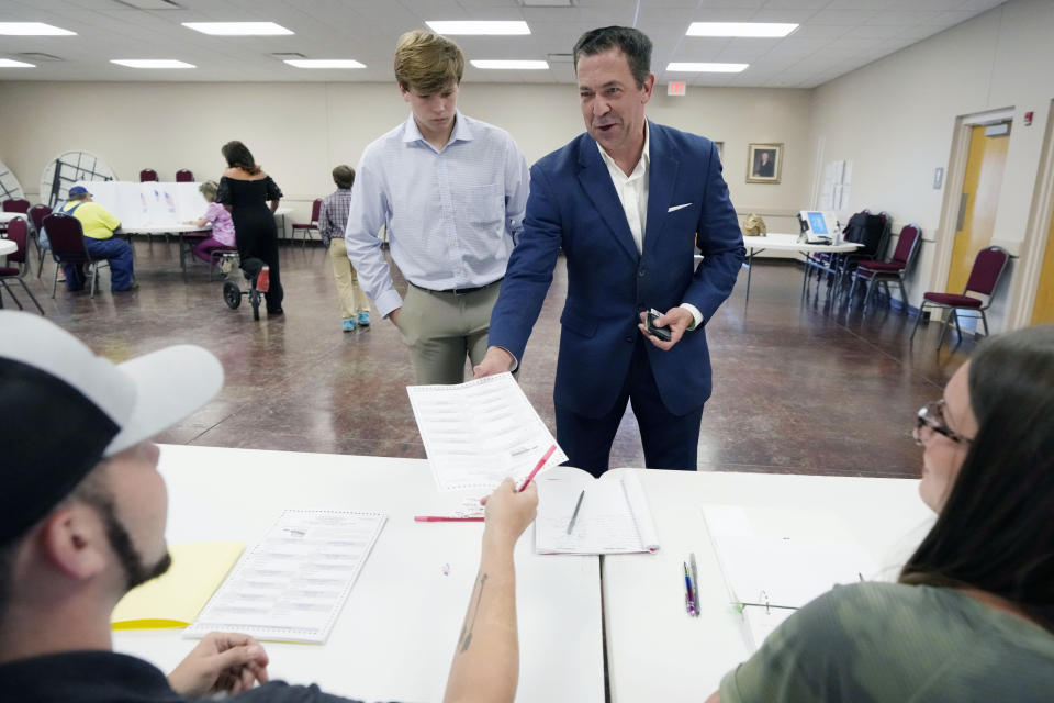 With his oldest son Cambridge McDaniel, 16, at his side, Republican State Sen. Chris McDaniel, right, picks up his party primary ballot from poll worker Micah Smith at his Ellisville, Miss., precinct, Tuesday, Aug. 8, 2023. McDaniel seeks the party's nomination as the candidate for lieutenant governor. However he faces incumbent Lt. Gov. Delbert Hosemann who is seeking reelection, and a political unknown. (AP Photo/Rogelio V. Solis)