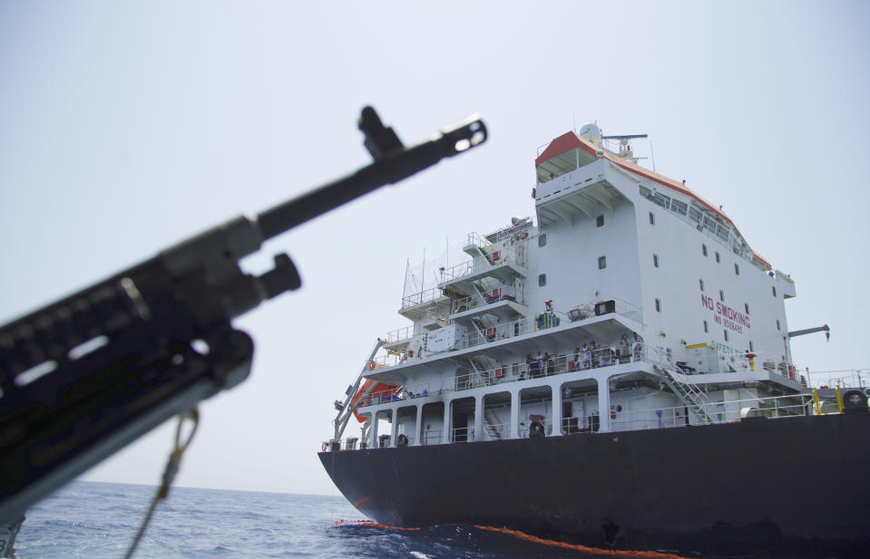 Sailors stand on deck above a hole the U.S. Navy says was made by a limpet mine on the damaged Panama-flagged, Japanese owned oil tanker Kokuka Courageous, anchored off Fujairah, United Arab Emirates, during a trip organized by the Navy for journalists, Wednesday, June 19, 2019. The limpet mines used to attack the oil tanker near the Strait of Hormuz bore "a striking resemblance" to similar mines displayed by Iran, a U.S. Navy explosives expert said Wednesday. Iran has denied being involved. (AP Photo/Fay Abuelgasim)