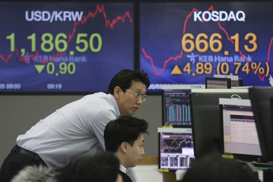 Currency traders watch monitors at the foreign exchange dealing room of the KEB Hana Bank headquarters in Seoul, South Korea, Wednesday, Feb. 5, 2020. Asian shares rose Wednesday on optimism that China's latest actions may help curtail some of the expected economic damage from the virus outbreak. (AP Photo/Ahn Young-joon)