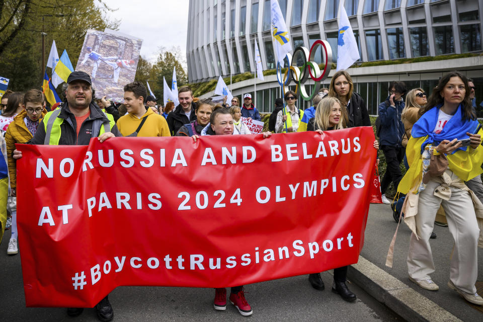 Members of the Geneva branch of Ukrainian society in Switzerland protest during a rally to urge International Olympic Committee to reconsider their decision of participation of Russian and Belarusian athletes under white neutral flag at the next 2024 Paris Olympic Games, in front of the IOC headquarters, in Lausanne, Switzerland, Saturday, March 25, 2023. (Jean-Christophe Bott/Keystone via AP)
