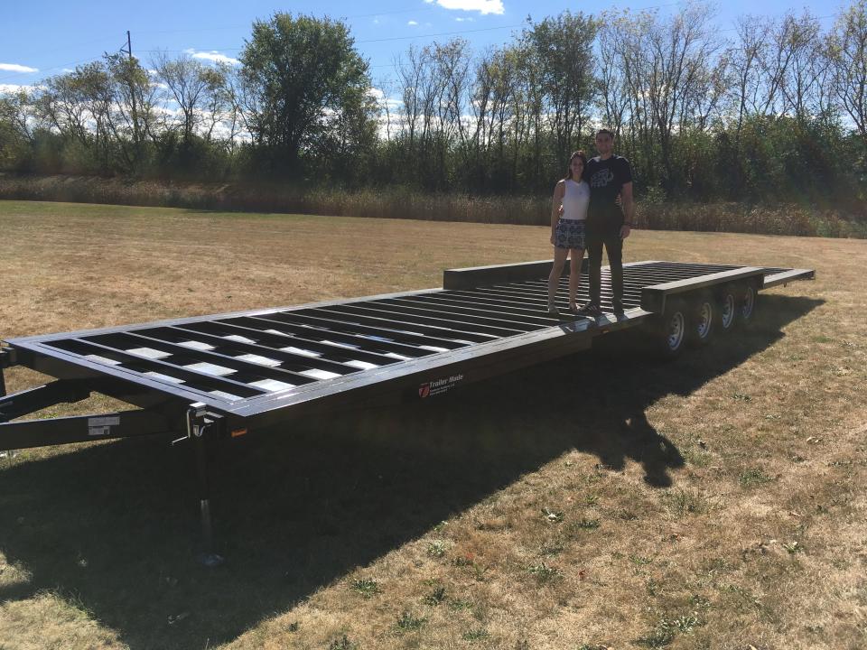 monica and alex standing on their newly purchased tiny house trailer