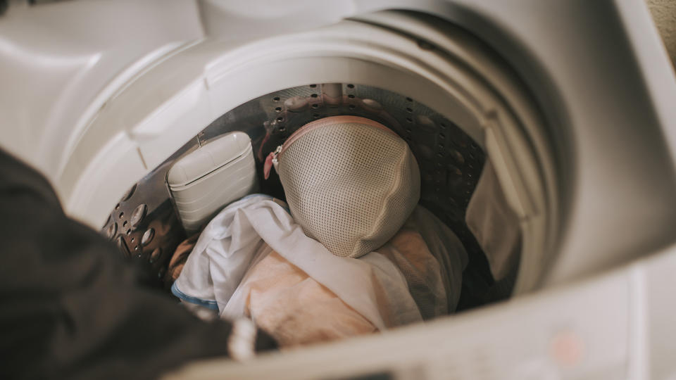 Top load washer open with clothes in the drum.