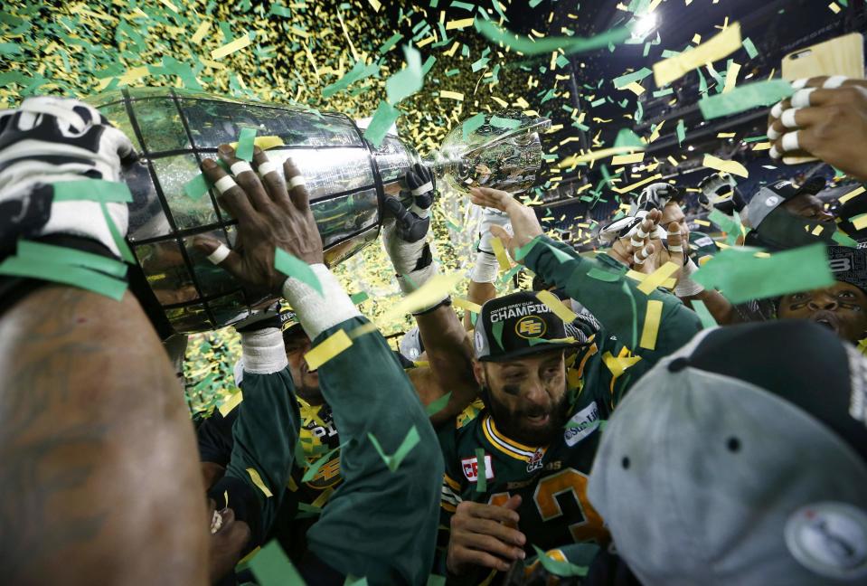 Edmonton Eskimos quarterback Mike Reilly is surrounded by his teammates as they raise the Grey Cup after his team defeated the Ottawa Redblacks in the CFL's 103rd Grey Cup championship football game in Winnipeg, Manitoba, November 29, 2015. REUTERS/Mark Blinch