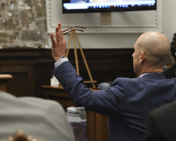 : Defense attorney Corey Chirafisi assumes a kneeling surrender position as he asks about Kyle Rittenhouse having his hands up as he approached Kenosha Police officer Pepe Moretti's squad car after the shootings, during the Kyle Rittenhouse trial at the Kenosha County Courthouse in Kenosha, Wis., on Friday, Nov. 5, 2021. Rittenhouse is accused of killing two people and wounding a third during a protest over police brutality in Kenosha, last year. (Mark Hertzberg/Pool Photo via AP)