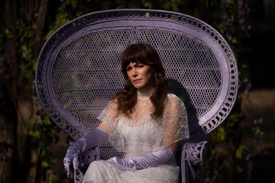 Jenny Lewis lounges in a wicker chair in the backyard of her East Nashville home.