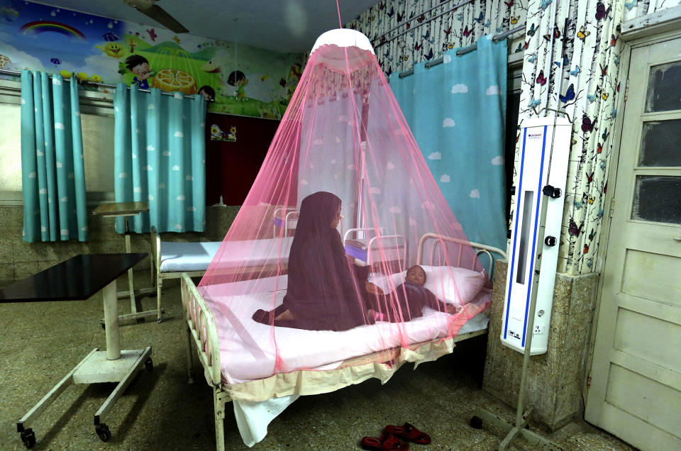 A mother takes care of her son, who suffers from dengue fever, a mosquito-borne disease, in a hospital in Karachi, Pakistan, on Nov. 22. (Fareed Khan / AP file)