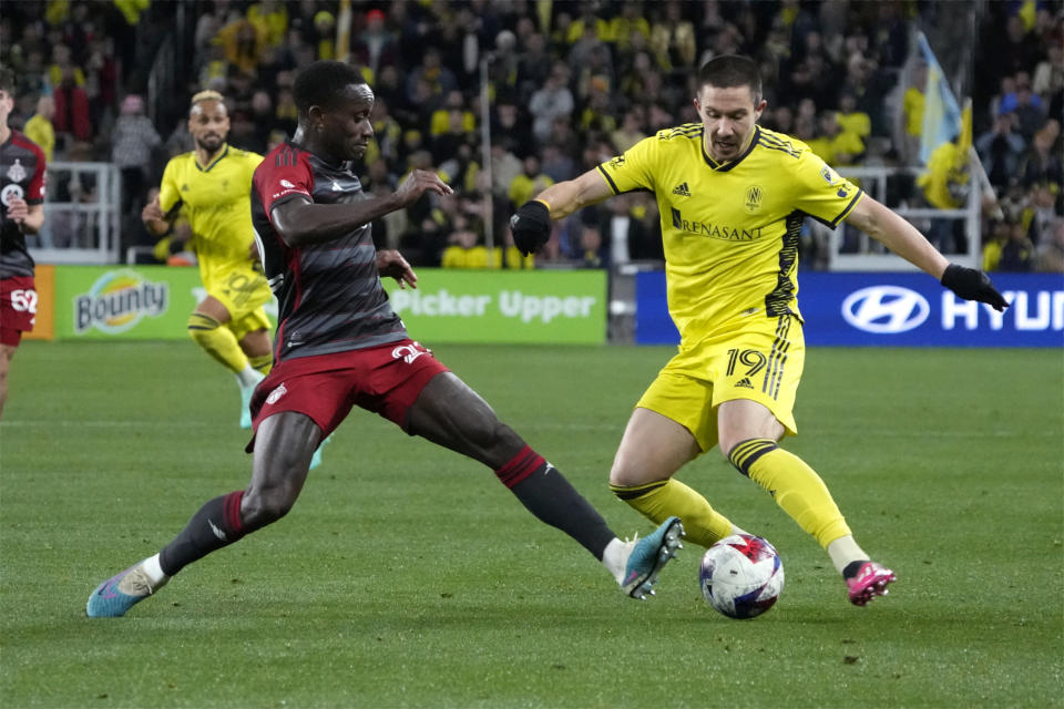 Toronto FC's Richie Laryea, left, and Nashville SC's Alex Muyl vie for the ball during the second half of an MLS soccer match Saturday, April 8, 2023, in Nashville, Tenn. (AP Photo/Mark Humphrey)