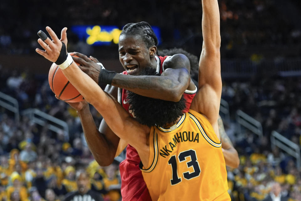 Ohio State center Felix Okpara (34) collides with Michigan forward Olivier Nkamhoua (13) in the first half of an NCAA college basketball game in Ann Arbor, Mich., Monday, Jan. 15, 2024. (AP Photo/Paul Sancya)