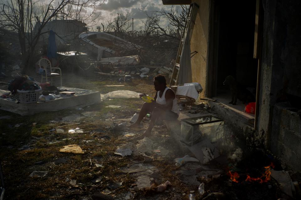 Tereha Davis, 45, eats a meal of rice as she sits among the remains of her shattered home, in the aftermath of Hurricane Dorian in McLean’s Town, Grand Bahama, Bahamas, Wednesday Sept. 11, 2019. She and others said they had not seen any government officials and have only received food and water from some nonprofit organizations. (AP Photo/Ramon Espinosa)