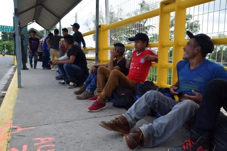 Migrants queue to request humanitarian visas to enter Mexico at the Rodolfo Robles international border crossing bridge, that connects Tecun Uman, Guatemala with Ciudad Hidalgo, Mexico, as seen from Ciudad Hidalgo