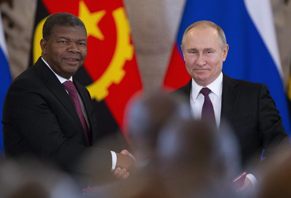 Vladimir Putin and Joao Manuel Goncalves Lourenco shake hands.