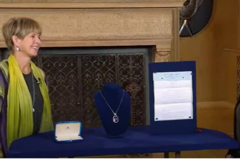 Antiques Roadshow host on one side of a table with the guest on the other
