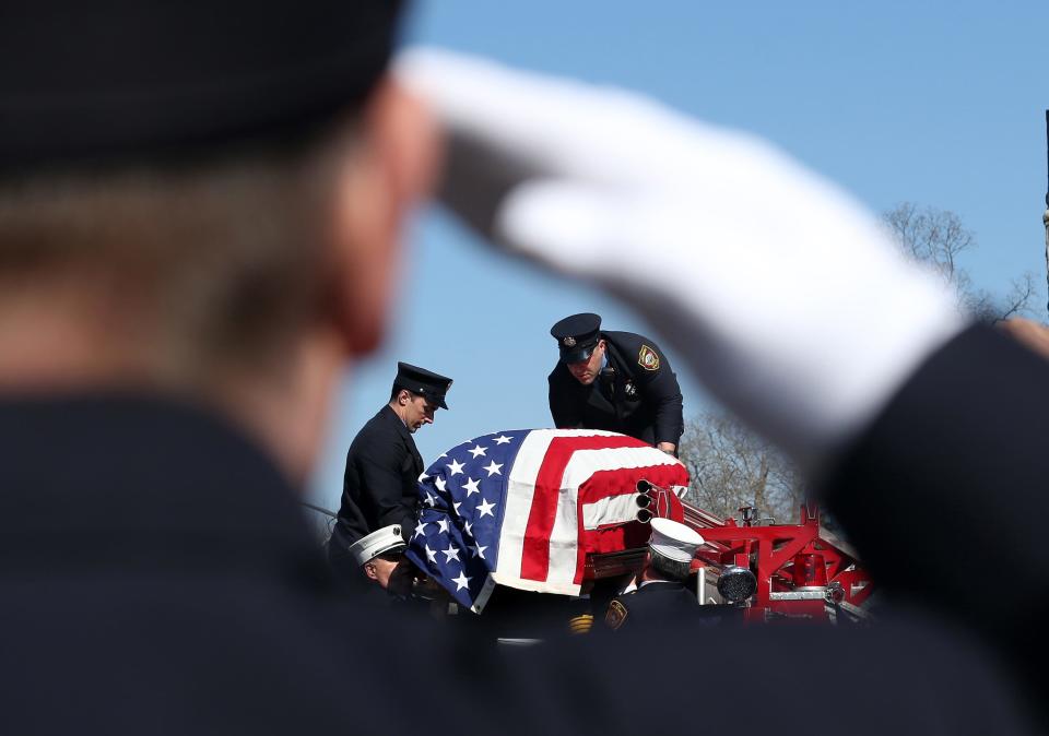 A Larchmont firefighter salute as fellow firefighters carry the flag draped coffin of Larchmont Fire Lt. John Veteri off his engine as the procession arrives at Saint James Church in Carmel for his funeral mass March 16, 2022. Lt. Veteri worked at Ground Zero after the Sept. 11 attacks, and died in 2022 of a Sept. 11-related cancer.