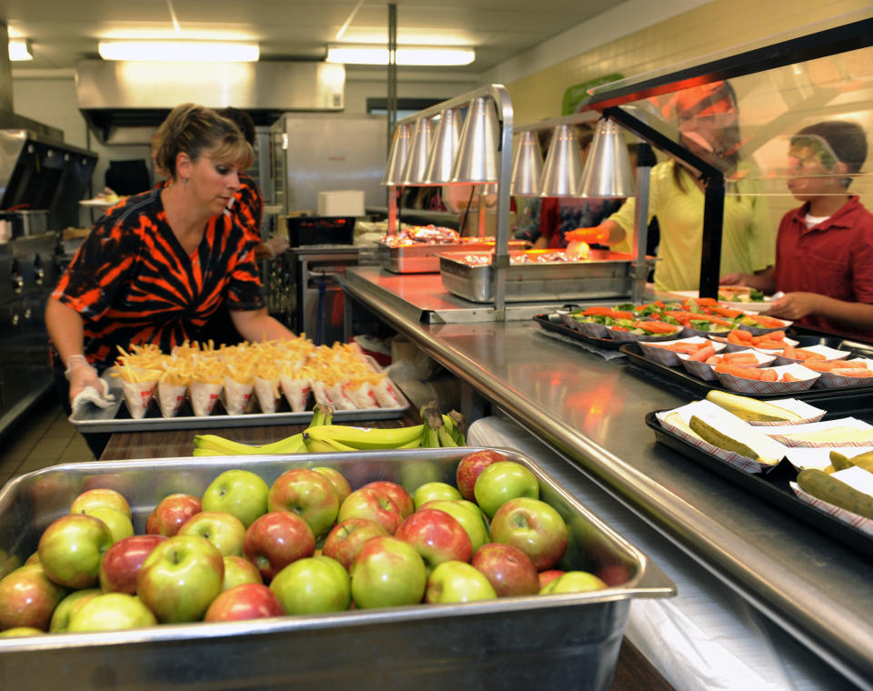 Michel Sasso, replenish's food items along the lunch line of the cafeteria at Draper Middle School in Rotterdam, N.Y., Tuesday, Sept. 11, 2012. The leaner, greener school lunches served under new federal standards are getting mixed grades from students. (AP Photo/Hans Pennink)