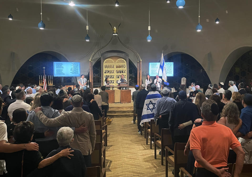 Cerca de 300 personas cantan al final de los servicios del sabat en un templo de Miami Beach, Florida, el viernes 13 de octubre de 2023. (AP Foto/Giovanna Dell'Orto)