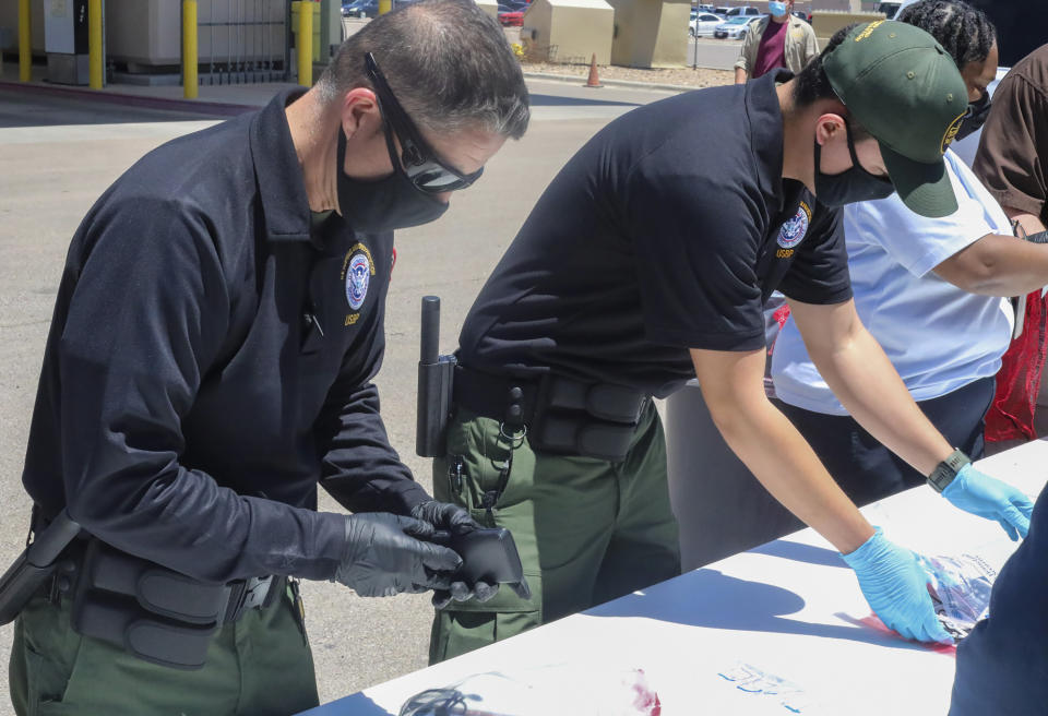 This May 4, 2021, photo provided by The U.S. Border Patrol shows U.S. Border Patrol Processing Coordinators help process and log personal items from migrants entering the Central Processing Center in El Paso, Texas. The Border Patrol says agents spend about 40% of their time on custody care and administrative tasks that are unrelated to border security, a staffing challenge that has come into focus with the arrival of thousands of Haitian migrants in the small Texas border city of Del Rio. (U.S. Border Patrol via AP)