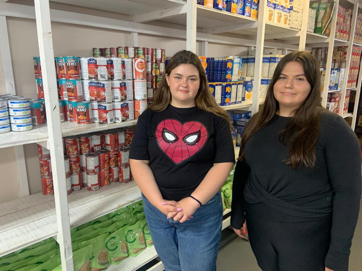 Kaitlin Clarke and Abigail Clark say it's becoming harder to keep the Carbonear food bank stocked. (Darrell Roberts/CBC - image credit)