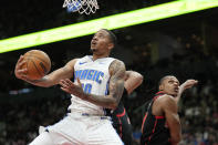 Orlando Magic guard Markelle Fultz (20) drives past Toronto Raptors guard Jahmi'us Ramsey (37) and another defender for a shot during the second half of an NBA basketball game Friday, March 15, 2024, in Toronto. (Frank Gunn/The Canadian Press via AP)