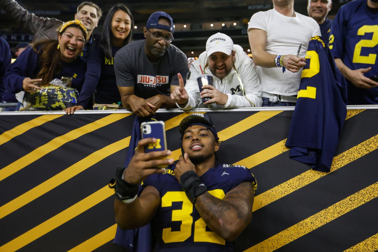 Michigan defensive end Jaylen Harrell takes a selfie with fans to celebrate the 34-13 win over Washington to win the national championship game at NRG Stadium in Houston on Monday, Jan. 8, 2024.