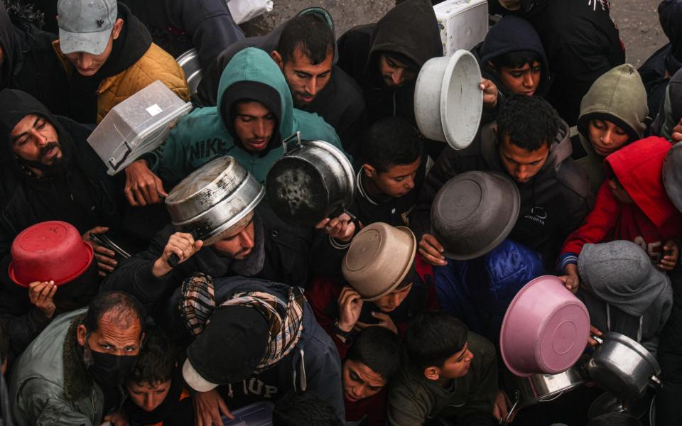 Palestinians are issued food rations at a camp in Rafah on Friday