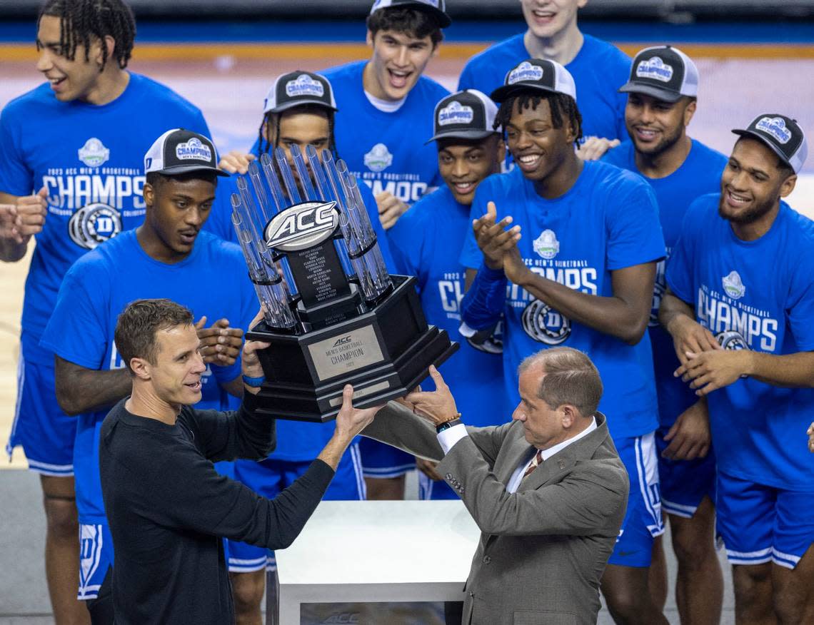 Duke coach Jon Scheyer accepts the ACC Tournament Championship trophy from ACC Commissioner Jim Phillips following their 59-49 victory over Virginia on Saturday, March 11, 2023 at the Greensboro Coliseum in Greensboro, N.C.