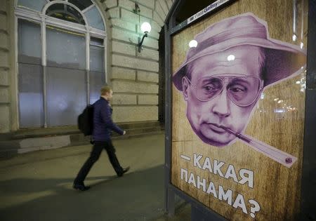 A man walks past a poster depicting Russian President Vladimir Putin and reading "Which Panama?" at a bus stop in Moscow, Russia, April 6, 2016. In Russian "panama" also means a bucket hat. REUTERS/Sergei Karpukhin