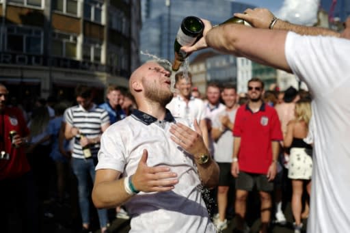 A man is drenched in champagne in a London street as England fans celebrate